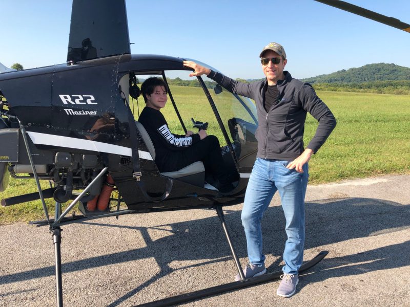 people near a helicopter posing for the camera