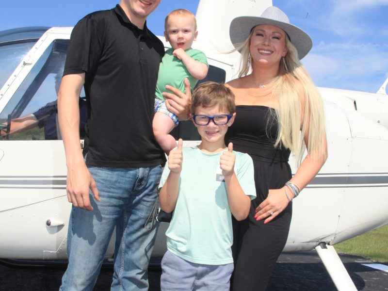 people near a helicopter posing for the camera