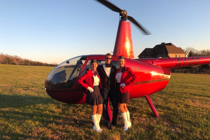 people near a helicopter posing for the camera